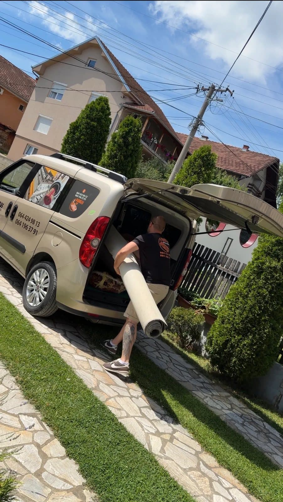 Član Bubbles tima unosi tepih u službeni kombi ispred kuće klijenta